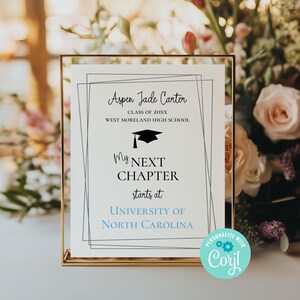 May include: A graduation announcement sign with a black and white design. The sign reads "Aspen Jade Carter, Class of 20XX, West Moreland High School, My Next Chapter starts at University of North Carolina". The sign is framed in gold and has a blue and white "Personalize with Coril" sticker.