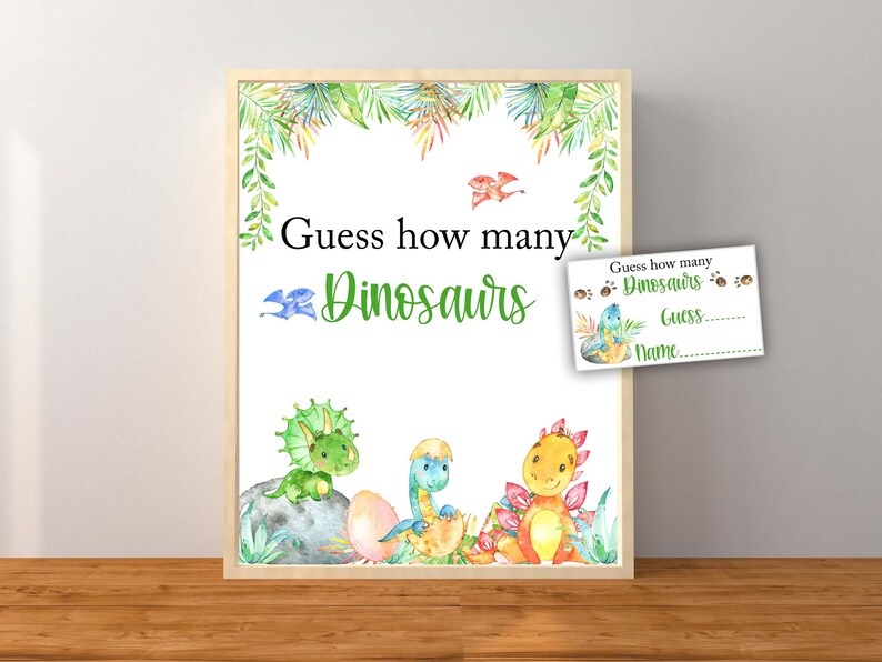 Op de afbeelding: Een afdrukbaar spelschild met een groen, wit en blauw kleurenschema. Het bord zegt "Raad hoeveel dinosaurussen" en bevat een cartoonillustratie van drie dinosaurussen. Een kleinere kaart met een ruimte om een gok en naam te schrijven is inbegrepen.
