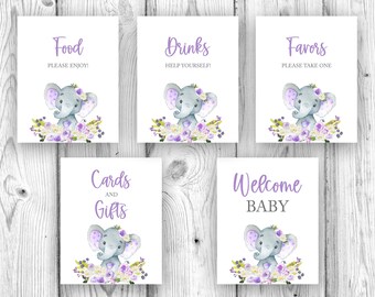 May include: Five printable baby shower signs with a purple and white floral design and a cute gray elephant illustration. The signs read "Food, Please Enjoy!", "Drinks, Help Yourself!", "Favors, Please Take One", "Cards and Gifts", and "Welcome Baby".