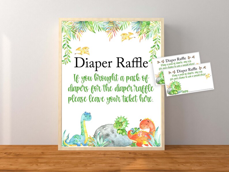 May include: A sign with a green and white dinosaur theme that says "Diaper Raffle. If you brought a pack of diapers for the diaper raffle please leave your ticket here." There are two smaller cards that say "Diaper Raffle. Bring a pack of diapers, any size, for your chance to win a special prize."