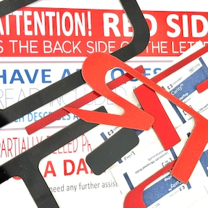 May include: A close-up of red and black letter shapes, with the text "ATTENTION! RED SIDE IS THE BACK SIDE OF THE LETTERS" visible in the background. The letters are made of a thick, sturdy material and have a slightly textured surface.