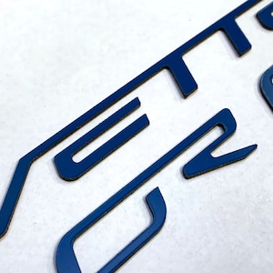 May include: Close-up of a blue "Vetro" logo, with the letters cut out of a solid blue material.