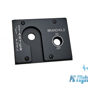 Może przedstawiać: Czarny metalowy panel z przełącznikiem typu „włącz/wyłącz” z napisem „BRAKEHOLD ON OFF” i dźwignią z napisami „JET FUEL STARTER”.
