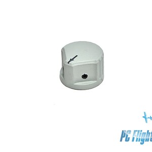 Op de afbeelding: Een grijze kunststofknop met een zwarte pijl die naar links wijst. De knop heeft een klein gaatje in het midden.