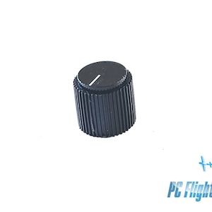 Op de afbeelding: Zwarte plastic knop met een witte streep aan de bovenkant.