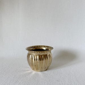 May include: A set of three ceramic mugs with a speckled, matte finish. The mugs are in shades of cream, light gray, and dark gray. Each mug has a simple, minimalist design, perfect for coffee or tea.