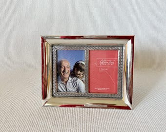 May include: Silver picture frame with a Greek key design border. The frame has two openings for photos. One opening shows a photo of a man and a woman. The other opening has a red label that says "Green Tree Gallery".
