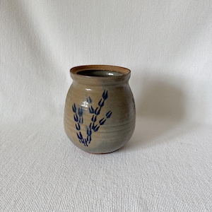 以下が含まれることがあります： ベージュの外観と茶色の縁を持つ、小さくて丸いセラミック花瓶。花瓶は青い抽象的な花の模様が特徴です。手作りの陶器は素朴でアースカラーの美しさがあり、小さな花を飾ったり、装飾的なアクセントとして適しています。