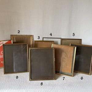 May include: A white ceramic mug with a black handle and the text "But First, Coffee" in a bold, black font. The mug is set against a blurred background, suggesting a cozy setting.