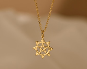 May include: A gold-colored necklace with a starburst pendant. The pendant features a star within a starburst design, suspended from a delicate chain. The necklace is displayed against a soft, neutral background.