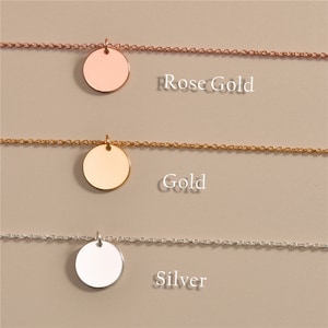 May include: Three delicate necklaces with round pendant charms in rose gold, gold, and silver. Each necklace features a simple chain.