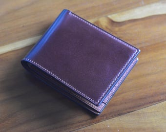 May include: A brown leather wallet with a stitched edge.
