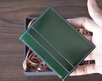 Tarjetero minimalista de tres bolsillos en piel de cordero con concha verde.