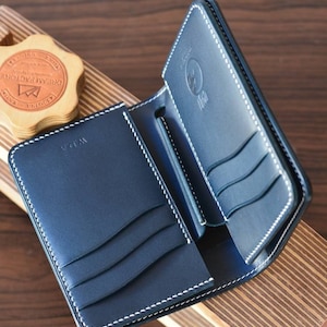 Cartera mediana de piel de cordero con concha negra y buttero azul marino. Cartera de regalo para hombre.