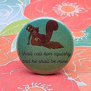 May include: A green button with a cartoon image of two squirrels hugging. The text on the button reads "I shall call him squishy and he shall be mine."
