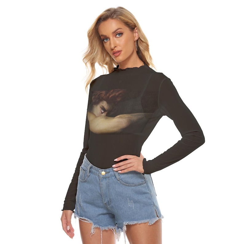 May include: Black long-sleeve top featuring a Renaissance painting print on the front. The top has a high, ruffled neckline and is paired with denim shorts. The artwork depicts a figure with red hair and a somber expression.