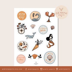 May include: A set of 12 colorful stickers with a beach and ocean theme. The stickers feature illustrations of seashells, a mermaid, a whale, a compass, and the text "seas of the day", "vitamin sea", "salty but sweet", and "mermaid hair don't care".