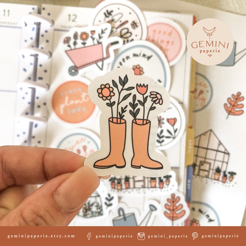 May include: A set of colorful stickers featuring a variety of gardening themes, including flowers, plants, a watering can, a greenhouse, and a pair of rain boots with flowers growing out of them. The stickers are perfect for adding a touch of whimsy to planners, journals, and other surfaces.