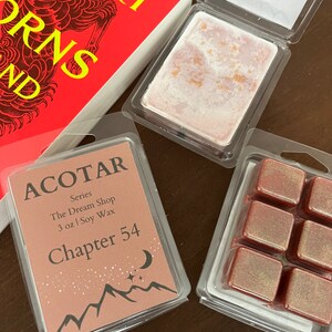 May include: Three wax melts in clear plastic containers. The wax melts are a deep red color with gold glitter. The containers are labeled "ACOTAR" and "Chapter 54".