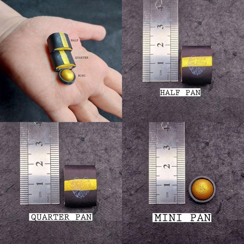 May include: Three sizes of eyeshadow pans: a full-size pan, a half-size pan, and a mini pan. The pans are black with a gold stripe and a design of a leaf. The pans are measured against a ruler in centimetres.