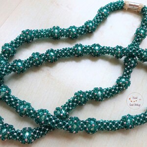 Cadena de manguera larga en verde esmeralda con cuentas de cera verde claro. Hecho a mano en óptica de malla. Cierre magnético. Portátil versátil