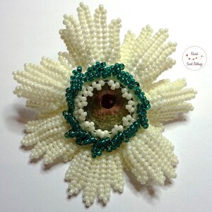 Fun brooch in the shape of a medal with an animal eye cabochon (chameleon) in the middle. Beige shimmering glass beads. For modern heroes and heroines