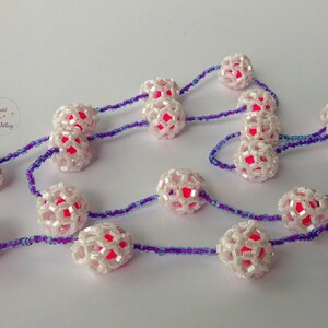 Long chain with balls of pearl-colored hexagon beads in the form of molecules (Buckminster Fullerene) filled with pink acrylic beads