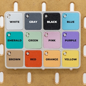 May include: A color palette with twelve square color swatches labeled with the colors white, gray, black, blue, emerald, green, pink, purple, brown, red, orange, and yellow. The color swatches are arranged in a grid.