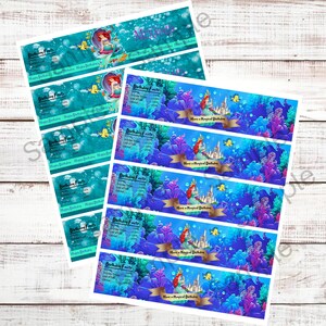 May include: Set of printable water bottle labels featuring a mermaid, a castle, and sea life. The labels are blue, green, and purple with gold accents. The text on the labels reads "Birthday Facts" and "Have a Magical Birthday".