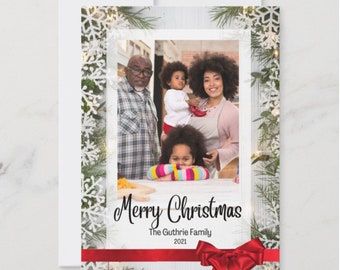 May include: A Christmas card featuring a family portrait with a white wooden background, a red ribbon, and the text "Merry Christmas The Guthrie Family 2021".