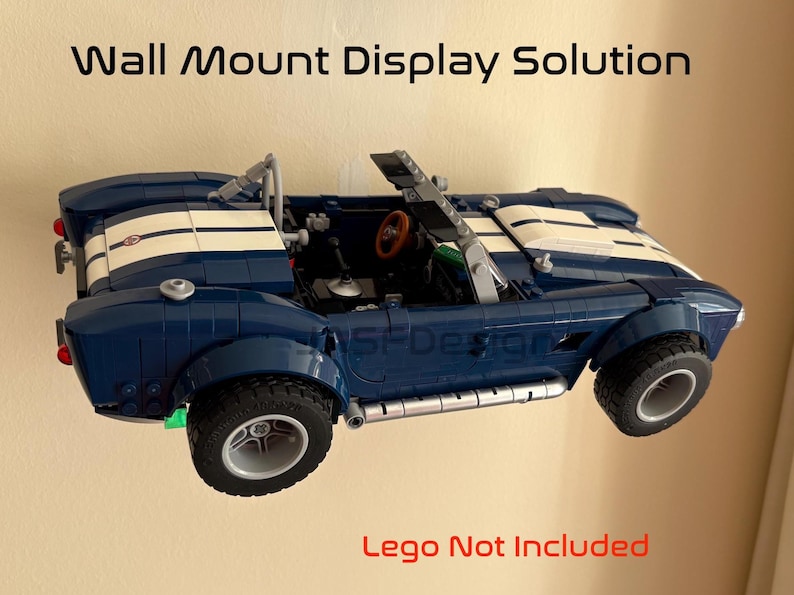 Op de afbeelding: Een blauwe speelgoedauto met witte racestrepen is aan de muur bevestigd. De auto heeft zwarte banden en een rood stuurwiel. De tekst "Wall Mount Display Solution" staat boven de auto.