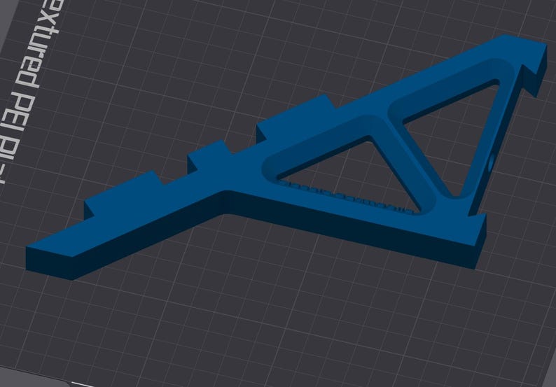 May include: A blue plastic 3D printed object with a triangular shape and a flat base. The object has a series of small rectangular protrusions along one side.