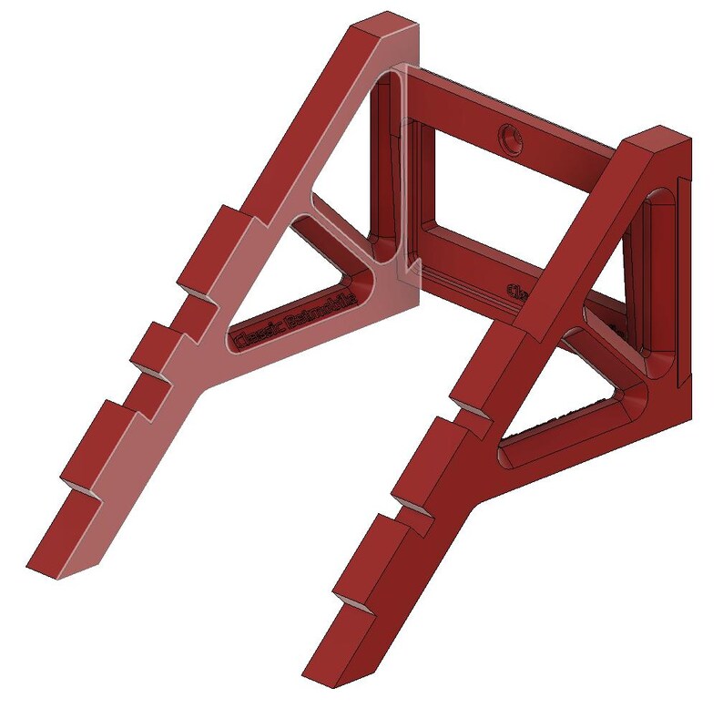 May include: A red plastic woodworking tool with a triangular shape and a rectangular opening. The tool has a series of notches on each side.