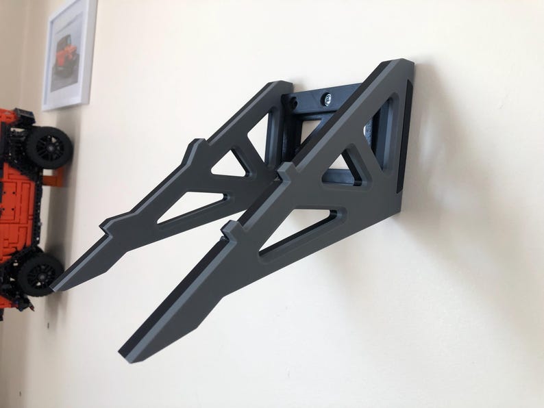 Puede incluir: Una estanter&iacute;a de pared negra con un dise&ntilde;o geom&eacute;trico. La estanter&iacute;a est&aacute; hecha de madera y tiene una forma triangular. Est&aacute; dise&ntilde;ada para sostener un port&aacute;til u otros dispositivos electr&oacute;nicos.