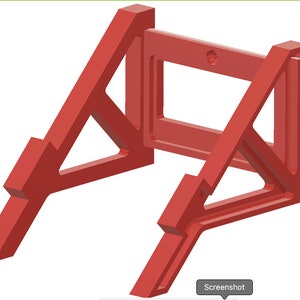 May include: Red plastic wall mount stand with a rectangular opening in the center. The stand is designed to hold a device or object.
