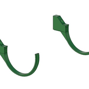 May include: Two green, curved wall hooks. Each hook has a rectangular mounting base with a circular indentation and a curved, hook-shaped portion extending downwards. The hooks are designed for hanging items.