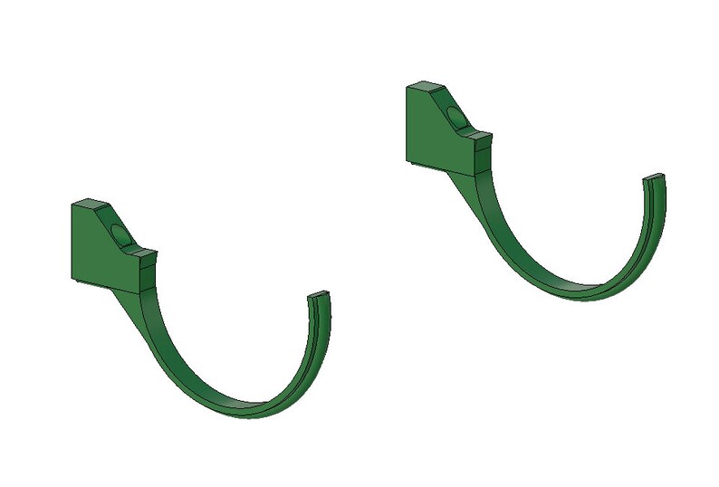 May include: Two green, curved wall hooks. Each hook has a rectangular mounting base with a circular indentation and a curved, hook-shaped portion extending downwards. The hooks are designed for hanging items.