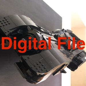 K&ouml;nnte beinhalten: Ein schwarzes Lego-Modell des Batmobils aus der Batman-Filmreihe. Das Modell ist an einer schwarzen Wand mit dem Text "Digital File" in roten Buchstaben angebracht.
