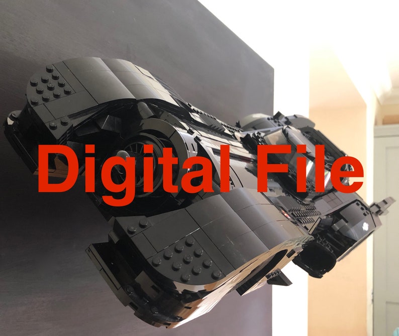 K&ouml;nnte beinhalten: Ein schwarzes Lego-Modell des Batmobils aus der Batman-Filmreihe. Das Modell ist an einer schwarzen Wand mit dem Text "Digital File" in roten Buchstaben angebracht.