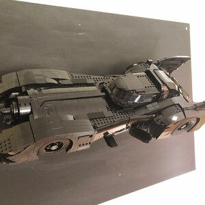 K&ouml;nnte beinhalten: Ein schwarzes Lego-Modell des Batmobils aus dem Batman-Film von 1989. Das Modell wird auf einem schwarzen Hintergrund pr&auml;sentiert.