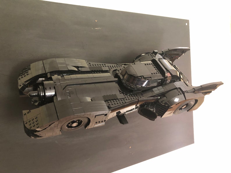 K&ouml;nnte beinhalten: Ein schwarzes Lego-Modell des Batmobils aus dem Batman-Film von 1989. Das Modell wird auf einem schwarzen Hintergrund pr&auml;sentiert.