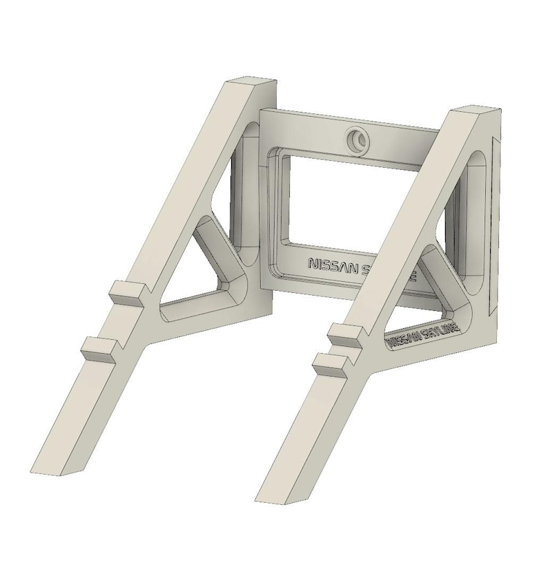 May include: A light beige, 3D-printed automotive part with the text "NISSAN SKYLINE" visible. The part has an A-frame design with a rectangular center and angled supports. The design includes a circular feature and additional text.