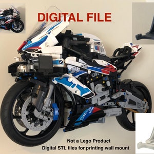 May include: A digital file for 3D printing a wall mount for a Lego motorcycle. The motorcycle is white, blue and black with a red stripe. The wall mount is a black triangular bracket. The text "DIGITAL FILE" is in red letters on a white background. The text "Not a Lego Product" is in black letters on a white background. The text "Digital STL files for printing wall mount" is in black letters on a white background.