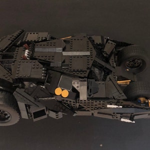 May include: A black Lego model of the Batmobile from the Batman movie series. The model is detailed and includes working wheels.
