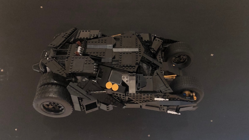 May include: A black Lego model of the Batmobile from the Batman movie series. The model is detailed and includes working wheels.