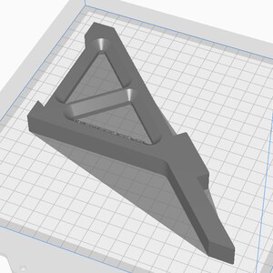 May include: A gray 3D printed model of a triangular support structure with a series of internal supports. The model is designed to provide stability and strength.