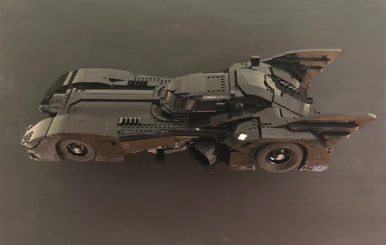 K&ouml;nnte beinhalten: Ein schwarzes Lego Batmobil Modell mit einem detaillierten Design und einer schlanken, aerodynamischen Form. Das Modell verf&uuml;gt &uuml;ber ein Cockpit, R&auml;der und einen Heckspoiler.