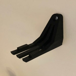 Peut inclure: Support mural en plastique noir avec trois pointes pour accrocher des objets.