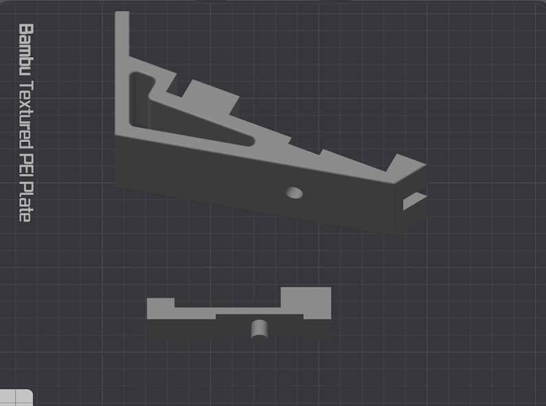 Puede incluir: Una pieza gris impresa en 3D con una superficie texturizada. La pieza est&aacute; dise&ntilde;ada para ser utilizada con una impresora 3D. El texto "Bambu Textured PEI Plate" es visible en el lado izquierdo de la imagen.