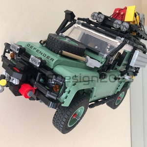 May include: A green Lego Land Rover Defender model with a black roof rack, spare tire, and a winch on the front bumper. The model has a detailed interior and exterior, including working headlights and taillights.